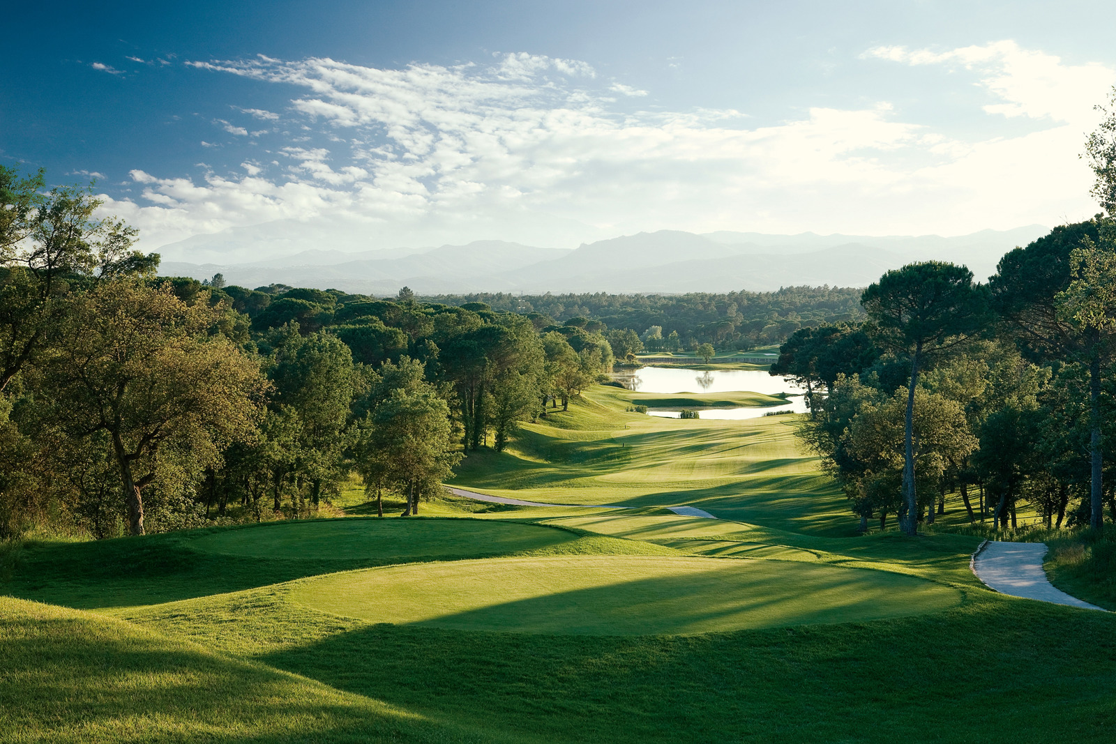 The 13th hole on the Stadium Course at Camiral, looking down the fairway towards the lake and the Girona hills