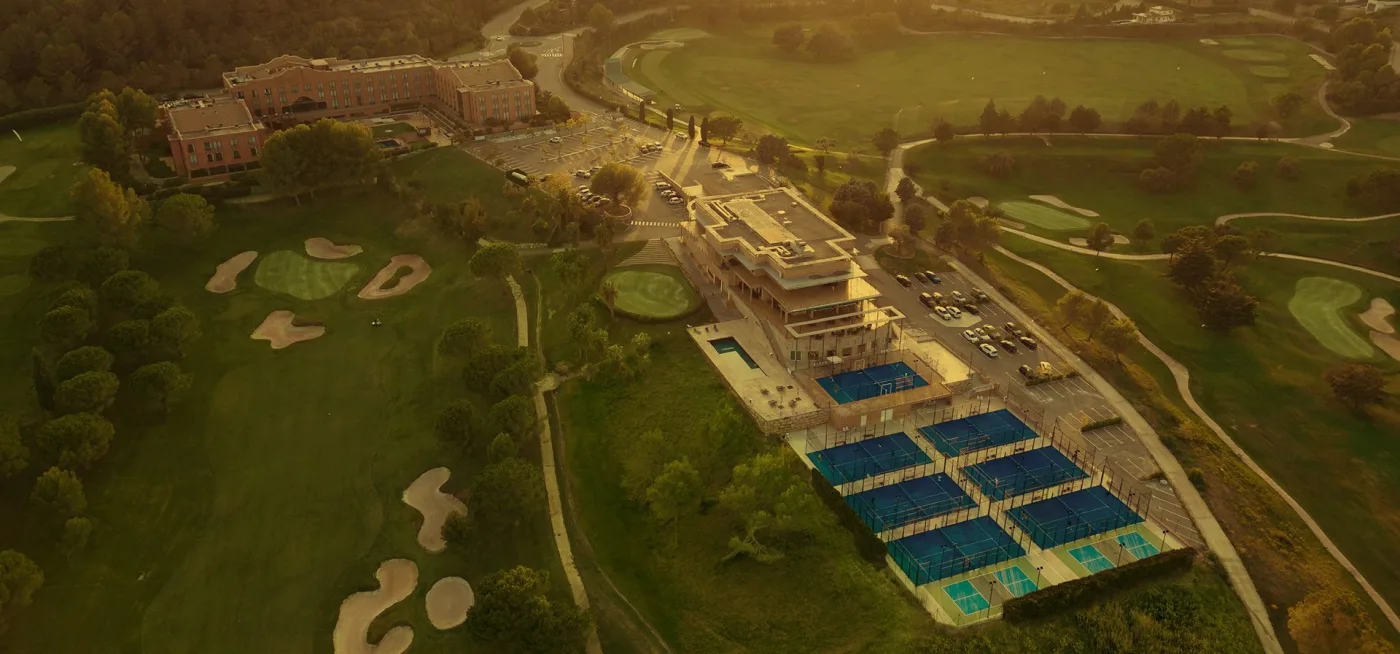 Aerial view of Club de Golf Barcelona, showing the clubhouse, fairways and practice areas at sunset