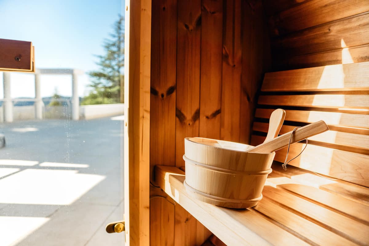 Inside the cedar sauna, with the pool terrace visible through the glass door